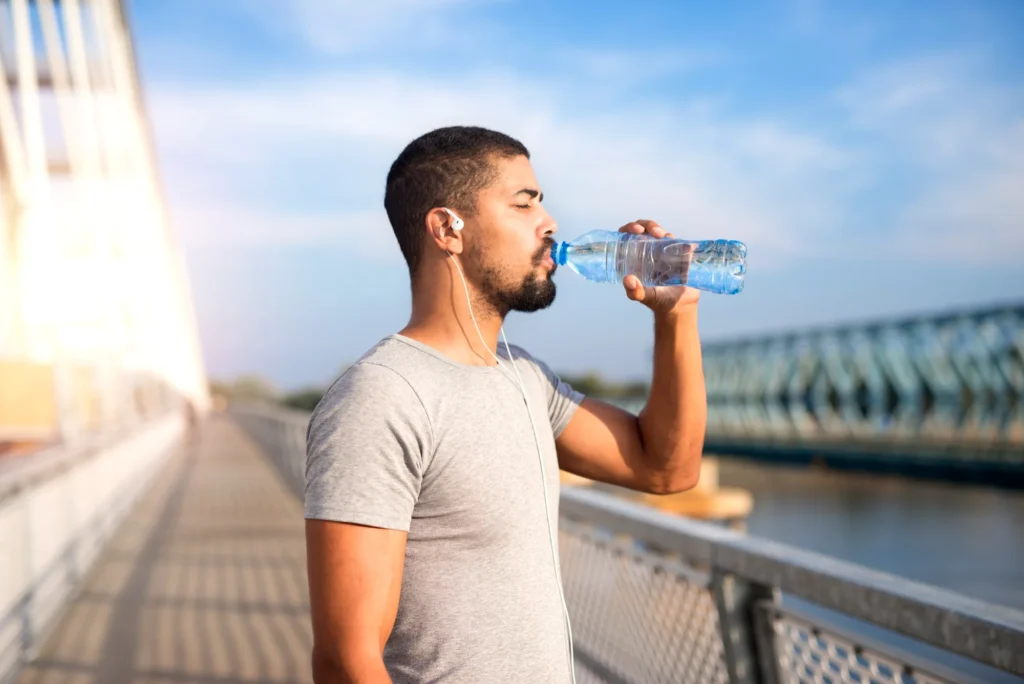 man drinking water in sunlight